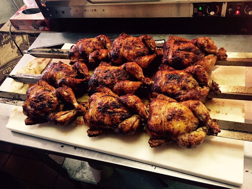 A tray of nine whole rotisserie chickens fresh off the brasa